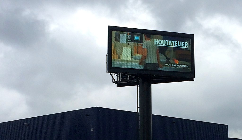 LED billboard op hoge paal bij industriegebouw